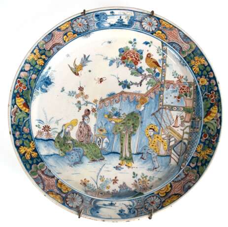 Fayence Platte, Delft, 1. Hälfte 18. Jh., polychromer Scharffeuerdekor im ostasitischen Stil, figürliche Darstellung mit hohen Frisuren, polychromer Rand mit Blumen und Vögeln, Rand und Rückseite mit Glasurfehlstellen, H… - photo 1