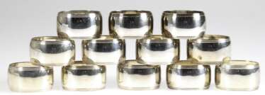 12 Serviettenringe, versilbert, oval, Ränder mit Rillendekor, H. 3 cm, L. 4,5 cm
