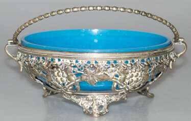 Henkelschale mit blauem Glaseinsatz, um 1900, durchbrochene silberfarbene Metallwandung mit Weinlaubdekor, Glasschale mit kl. Randchip, H. (ohne Henkel gemessen) 8 cm, Dm. 18 cm