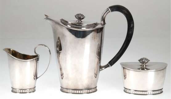 Kaffeekernstück, Schweden 1959, GAB, Silber, punziert, 1152 g, bestehend aus Kaffeekanne, im Querschnitt ovale Form mit Holzhenkel und Scharnierdeckel, H. 21 cm, Zuckerdose und Sahnekännchen - фото 1
