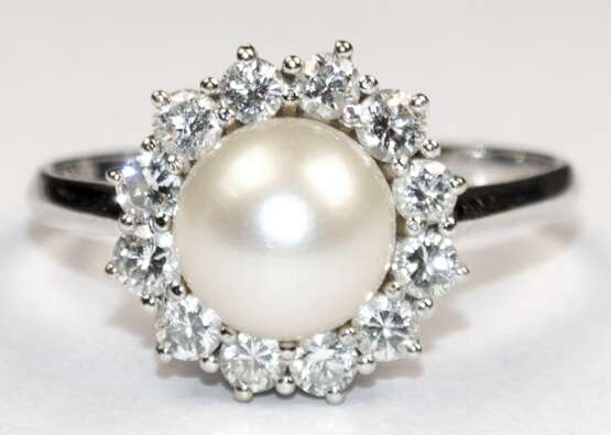 Ring, 750er WG, besetzt mit 1 Perle, Dm. 0,8 cm, die von 12 Brillanten von zus. ca. 0,48 ct. umrandet wird, Ges.-Gew. 5,04 g, RG 61,5 - photo 1