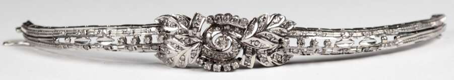 Armband, ägyptisch punziert 12, 500er GG weißvergoldet/rhodiniert, floral gestaltetes, durchbrochenes Mittelteil, Schauseite besetzt mit 19 kl. Brillanten von zus. ca. 0,5 ct. und kl. Diamantrosen, Steckschloß mit Siche… - фото 1