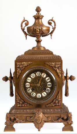 Historismus-Pendule, um 1880, Bronzeguß, 1/2-Stundenschlag auf Glocke (nicht fkt.), reich reliefiertes Gehäuse mit Amphore als Bekrönung, Pendel mit Blattfederaufhängung, reliefiertes Zifferblatt mit Emailleplaketten mit… - Foto 1