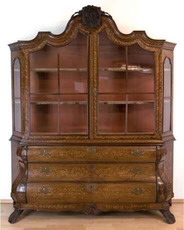 Barock-Aufsatzvitrine, Holland um 1750, Nußbaum furniert, 3-schübiges, frontseitig geschweiftes Kommodenteil mit abgeschrägten Seiten, 2-türiger Aufsatz mit schrägen Seiten, 3-seitig sprossenverglast, geschweifter Profil… - photo 1