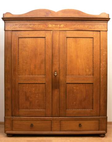 Biedermeier-Kleiderschrank, Eiche z.T. intarsiert, geschweiftes Gesims mit Inschrift "I. Elisabeth Meyn Anno 1846", 2-türig, im Sockel 2 Schubladen, die innen durch Stifte verriegelbar sind, Zierleisten in Türf… - photo 1