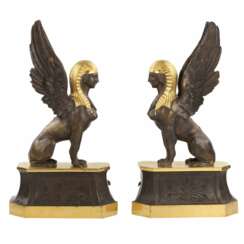 Une paire de b&ucirc;chers en bronze patin&eacute; et dor&eacute; se pr&eacute;sente en forme de sphinx ail&eacute;s. 19&egrave;me si&egrave;cle. 