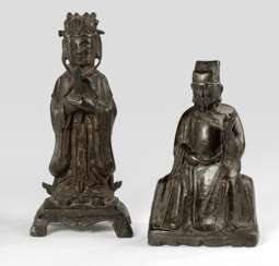 Zwei daoistische Offizielle, sitzend bzw. stehend auf einem Sockel dargestellt