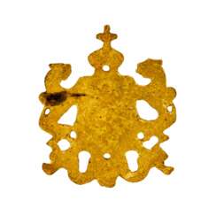 Metal patch in the form of a coat of arms.