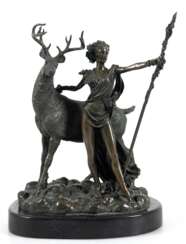 Bronze-Figur &quot;Diana mit Hirsch&quot;, braun patiniert, bezeichnet &quot;Coreira&quot;, auf ovalem schwarzem Steinsockel, Ges.-H. 27,5 cm