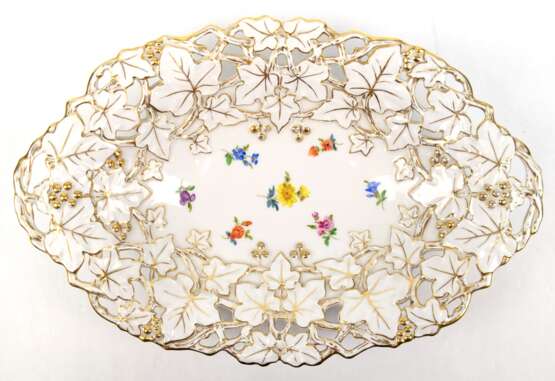 Meissen-Prunkschale, oval, durchbrochener Rand mit goldkonturiertem Efeulaub, mittig polychrome Streublümchen, 1. Wahl, H. 5,5 cm, L. 32 cm - photo 1
