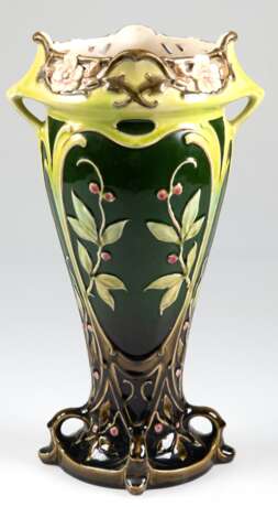 Jugendstil-Vase, Majolika, mit farbig glasiertem und z.T. goldkonturiertem Floralrelief, unterhalb vom durchbrochenen Rand 2 kleine Henkel, unter ovalem Fuß Preß-Nr. 20858, Wandung mit Haarrissen, H. 39 cm - photo 1