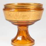 Art-Deco-Fußschale, Moser, bernsteinfarbenes Glas mit Goldbemalung, Schale mit goldener Reliefbordüre mit Wein- und Vogeldekor, Gold partiell berieben, H. 19 cm, Dm. 19 cm - photo 1