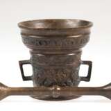 Mörser mit Pistill, Altbeschriftung, Bronze, umlaufend ornamental reliefiert, 2 gekantete Henkel, H. 8,5 cm, Pistill-L. 15 cm - photo 1