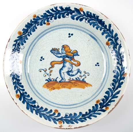 Fayence-Teller, 18. Jh., tief gemuldet, figürliche und florale Malerei in Blau und Gelb, Dm. 35 cm - photo 1