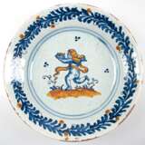 Fayence-Teller, 18. Jh., tief gemuldet, figürliche und florale Malerei in Blau und Gelb, Dm. 35 cm - photo 1