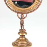 Schminkspiegel, figürlich, Bronze, Frankreich 19. Jh., auf beschwertem, getrepptem Rundfuß steht plastischer Putto und trägt schwenkbaren Spiegel (mit Blindstellen), Ges.-H. 30 cm, Spiegel-Dm. 11 cm - Foto 1