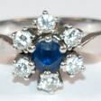 Saphir-Brillant-Ring, 585er WG, blütenförmiger Ringkopf besetzt mit 6 Brillanten von zus. ca. 0,5 ct. und 1 rund facettierten Saphir, Ges.-Gew. 4,41 g, RG 55 - Jetzt bei der Auktion