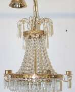Möbel. Deckenleuchter mit reichem Kristallbehang, an reliefiertem Metallreif 5 Kerzenhalter und innen 3 Glühlampen, H. ca. 85 cm, Dm. 46 cm