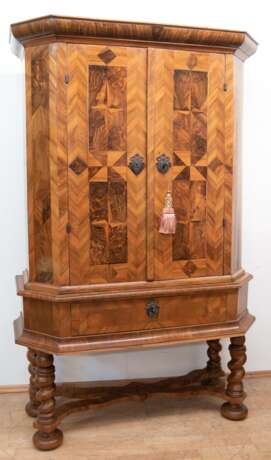 Barock-Stollenschrank, Nußbaum, Fußgestell mit 4 verstrebten gewundenen Säulen und 1 Schublade teilweise ergänzt, 2-türiger, intarsierter Aufsatz, innen 2 Einlegeböden und 2 Schubladen, leichte Furnierschäden, schleifenb… - Foto 1