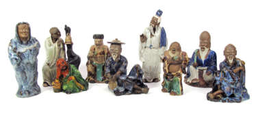 Neun farbig glasierte Figuren aus Irdenware mit Darstellung alter Männer