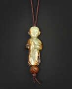 Edelsteine. A RARE PALE YELLOW AND RUSSET JADE CARVING OF A BOY HOLDING A BIRD
