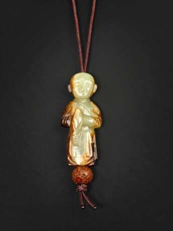 A RARE PALE YELLOW AND RUSSET JADE CARVING OF A BOY HOLDING A BIRD - photo 1
