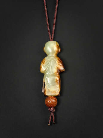 A RARE PALE YELLOW AND RUSSET JADE CARVING OF A BOY HOLDING A BIRD - photo 2