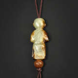 A RARE PALE YELLOW AND RUSSET JADE CARVING OF A BOY HOLDING A BIRD - photo 2