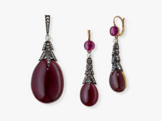 A demi-parure consisting of a pendant/locket and a pair of drop earrings with garnets, diamonds, and white pearls
