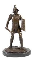 Bronze-Figur &quot;Gladiator&quot;, braun gefasst, Nachguß, bez. &quot;Omerth&quot;, Gießerplakette &quot;JB Deposee&quot;, auf ovaler schwarzer Steinplinthe, Ges.-H. 27,5 cm