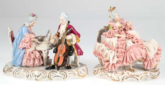 2 Porzellan-Figuren im Rokokostil, Dresden, "Das Duett- Dame am Piano und Herr mit Cello" und "Dame im Rüschenkleid auf Recamiere sitzend", jeweils mit reichem Spitzenbesatz (etwas best.). polychrom … - Foto 1