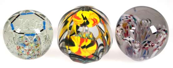 3 diverse Paperweights, davon 2x farblose abgeflachte Glaskugeln mit farbigen Einschmelzungen in Blütenform bzw. Monogr. "KB" und 1x runde facettierte Form mit Blüten, Dm. 7,5 cm- 9 cm - фото 1