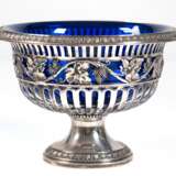Fußschale mit blauem Glaseinsatz, 800er Silber, Wilkens, durchbrochene Schale mit Traubendekor auf Rundfuß, Ränder mit Palmettenrelief, Gew. (ohne Glaseinsatz) 478 g, H. 15,5 cm, Dm. 20,5 cm - photo 1