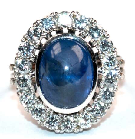Saphir-Brillant-Ring, 585er WG, ausgefaßt mit 1 ovalen Saphir-Cabochon von ca. 7,15 ct., helles Blau und 18 Brillanten von zus. ca. 1,08 ct., LR - VVS, Ges.-Gew. 8,44 g, RG 49(Wiederbeschaffungswert lt. Expertise 4.190,-… - фото 1