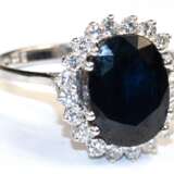 Saphir-Brillant-Ring, 585er WG, ausgefasst mit 1 oval facettierten, dunkelblauen Saphir und 20 kl. Brillanten von zus. ca. 0,6 ct, Ges.-Gew. 4,58 g, RG 55 - photo 1