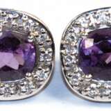 Amethyst-Brillant-Ohrstecker mit Klappbrisur, 750er WG (geprüft), je mit 1 oval facettierten Amethyst, umrandet von 14 Brillanten von zus. ca. 0,28 ct., Ges.-Gew. 8,26 g, je 1,8x1,4 cm - фото 1
