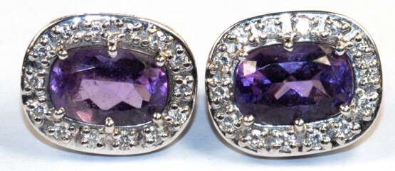 Amethyst-Brillant-Ohrstecker mit Klappbrisur, 750er WG (geprüft), je mit 1 oval facettierten Amethyst, umrandet von 14 Brillanten von zus. ca. 0,28 ct., Ges.-Gew. 8,26 g, je 1,8x1,4 cm - фото 2