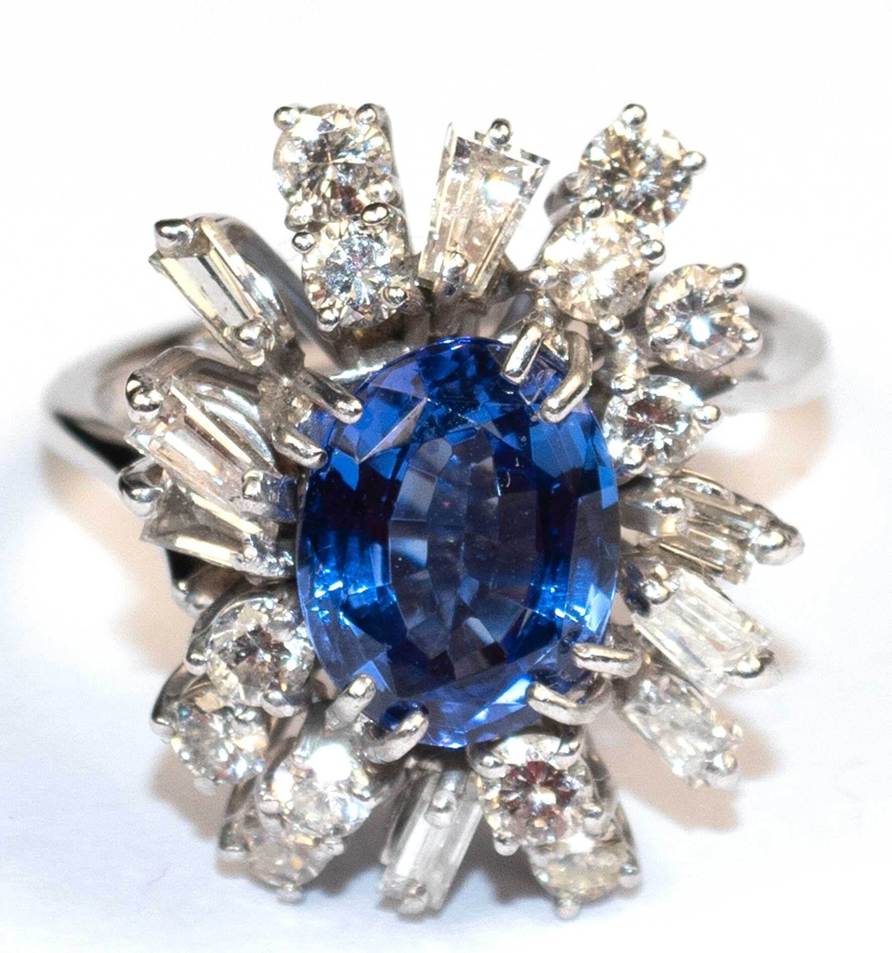 Tansanit-Brillant-Diamant-Ring, 750er WG, aus gefasst mit 1 Tansanit in Ovalschliffvariation von ca. 2,43 ct., 12 Brillanten von zus. ca. 0,67 ct., 6 Diamanten im Baguetteschliff von zus. ca. 0,47 ct. und 2 Diamanten im …