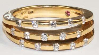 Brillant-Ring, 750er Gold, dreigeteilte Schiene besetzt mit 15 Brillanten von zus. ca. 0,30 ct., innen in der Schiene 1 kleiner Rubin, Ges.-Gew. 10,41 g, RG 57