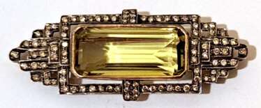 Brosche im Art-Deco-Design, 750er GG, 12,9 g, großer Lemon-Citrin von ca. 18,8 ct., Brillanten zus. ca. 1,11 ct., in Silberfassung, Maße ca. 5,3 x 2,1 cm