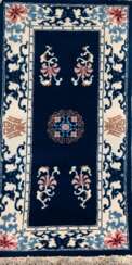 Teppich, Schurwolle, blaugrundig mit hellem Rand, floral und ornamental gemustert, 72x152 cm