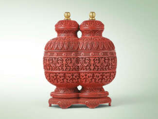 A CARVED CINNABAR LACQUER ‘PHOENIX AND DRAGON’ CONJOINED-VASE-FORM THREE-TIERED BOXES, COVERS AND STAND