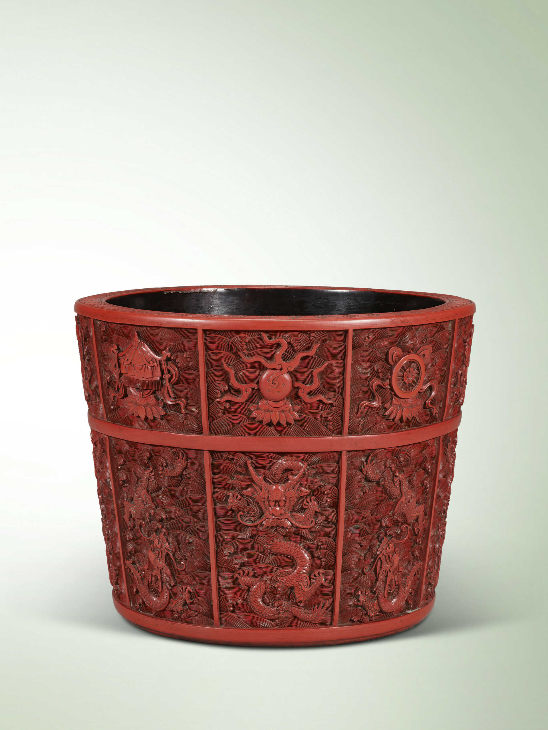 A CARVED CINNABAR LACQUER ‘NINE DRAGONS AND BAJIXIANG’ JARDINI&#200;RE