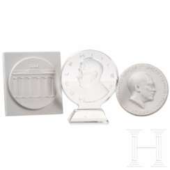 Zwei Porzellanplaketten und eine gläserne Plakette