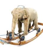 Каталог товаров. Steiff Elefant als Reittier auf Rädern mit Wippe