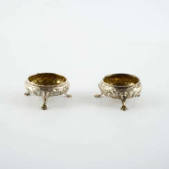 TWO SILVER FOOTED GEORGE II SALT CELLARS WITH FLORAL RELIEF