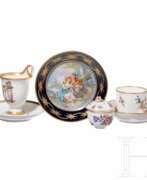 Keramische Waren. Zwei Tassen mit Untertassen, kleine Deckeldose und figürlicher Teller, KPM/Meissen/Sevre/Saint Maurice, 19. Jhdt.