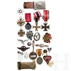 A collection of pins, badges, insignia, a belt buckle, etc.