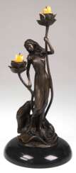Kerzenständer im Jugendstil, figürlich "Junge Frau im fließenden Gewand mit 2 blütenförmigen Kerzenhaltern ", Bronze, braun patiniert, bez. "Milo", Gießerplakette "J.B. Deposee Paris", auf …