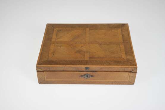 Schmuckkasten, Ende 19. Jh., Furnier aus divers. Holzarten, innen 10 Fächer, davon 6 mit Abdeckung, Innendeckel mit Klappspiegel, Boden mit Schwundriß, Schloß ohne Schlüssel, 7,5x26,5x19,5 cm - Foto 1 Schmuckkasten, Ende 19. Jh., Furnier aus divers. Holzarten, innen 10 Fächer, davon 6 mit Abdeckung, Innendeckel mit Klappspiegel, Boden mit Schwundriß, Schloß ohne Schlüssel, 7,5x26,5x19,5 cm - Foto 1